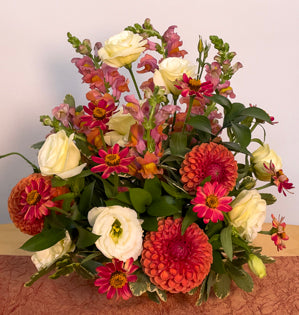 A classic vase design created with variegated pittosporum, dahlias, zinnias, lisianthus, and snapdragons.