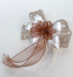 A beautiful bow created with copper sheer ribbon for the center, ivory satin ribbon for the middle, and then backed by a textural raffia ribbon.