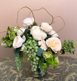 A lovely compote design made with faux grapes, Italian ruscus, Bessie garden roses, carnations, hellebore, and curly willow.